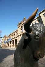 Bull in front of the stock exchange building (portrait)